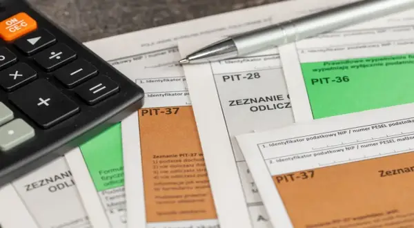 Kalkulator i długopis na formularzach PIT-37, PIT-28, PIT-36. Czas rozliczyć podatki, nawet jeśli masz kryptowaluty.
